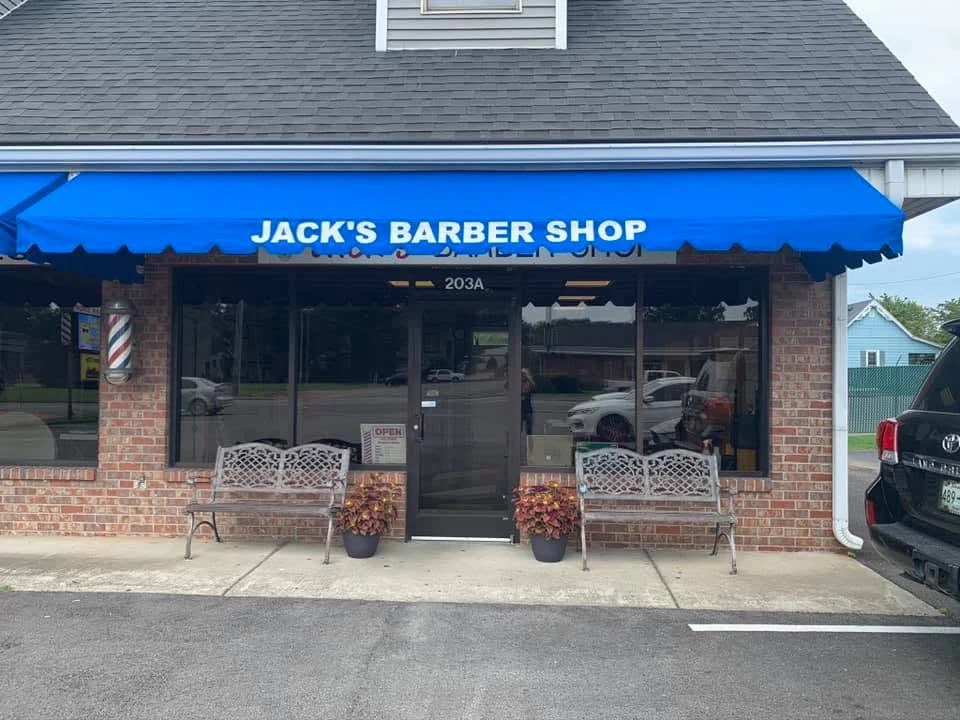 Jack’s blue awning, barber pole, and brick storefront on South Broadway