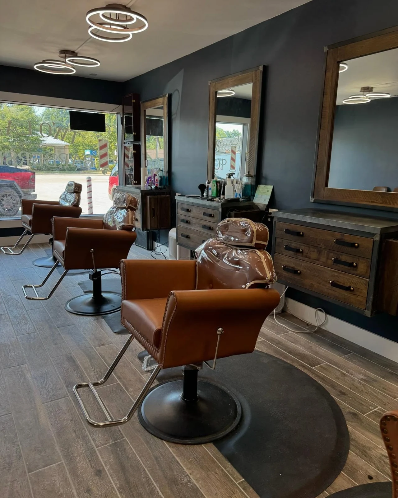 Warm leather barber chairs and wood stations inside The Cutting Edge