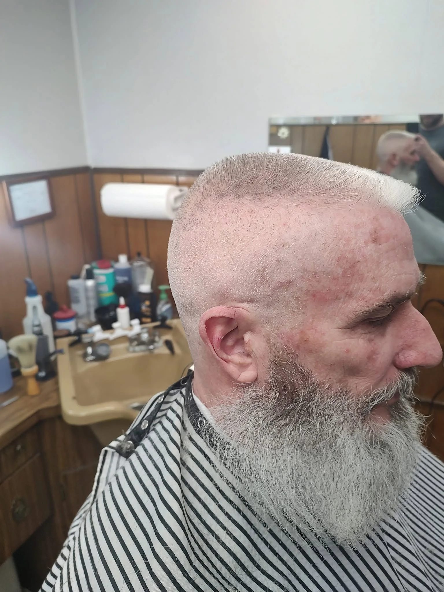 Customer with a white beard after a visit to the barber shop